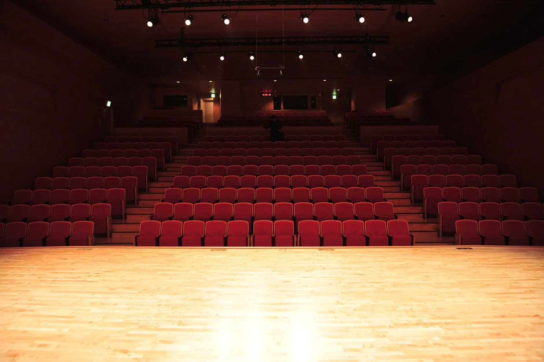 Ahşap koltuklu bir tiyatro salonunda opera izleyicileri