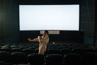 Teknoloji temalı karanlık bir sinema salonunda perdeye yansıyan görüntü
