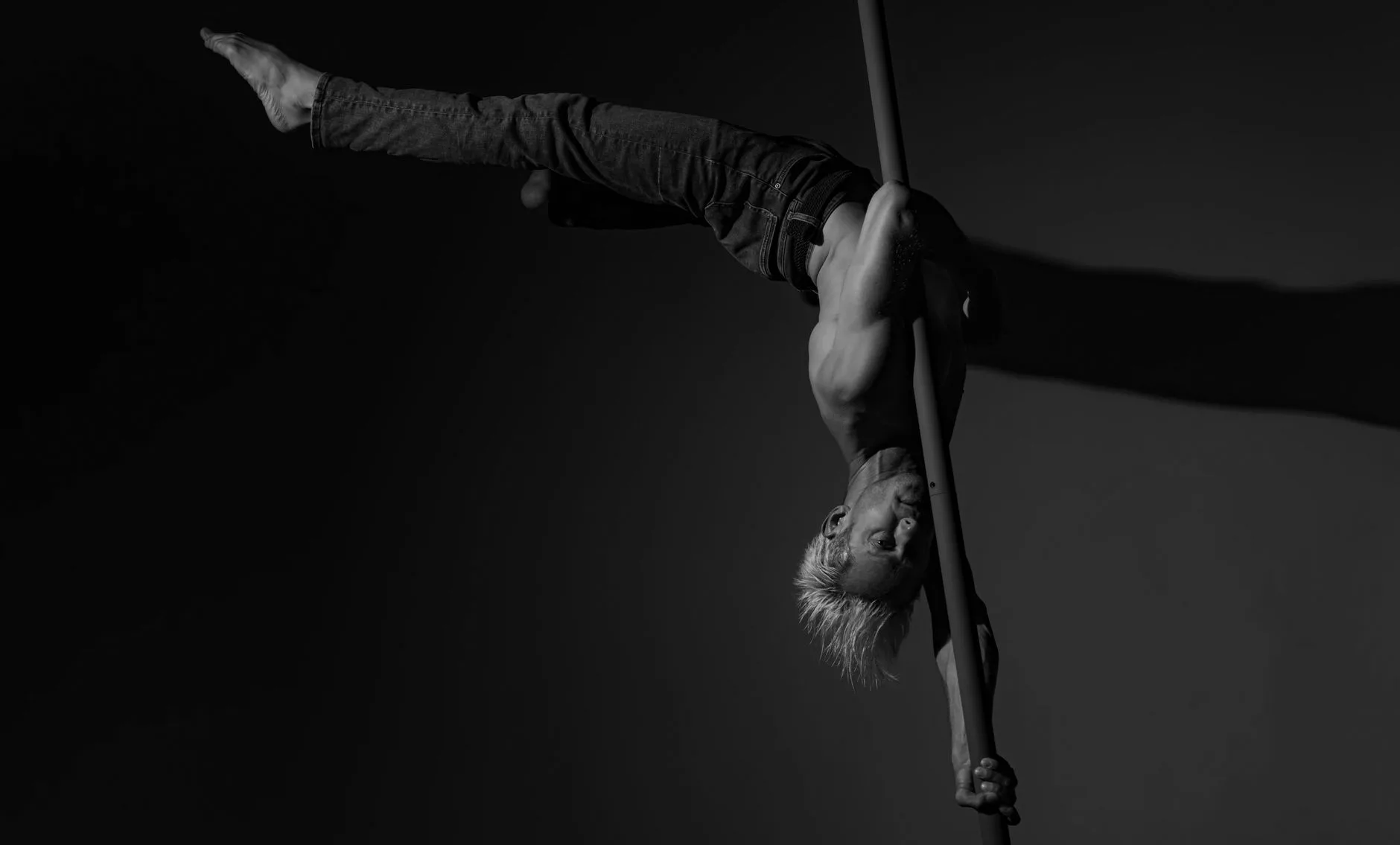 Sahnenin üzerinde asılı direkte performans yapan dansçı