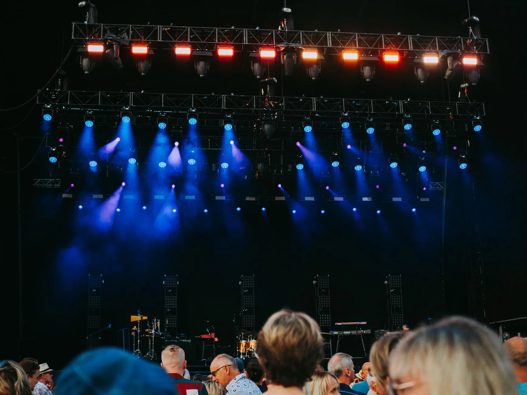 Sahne ışıkları altında konser izleyen kalabalık