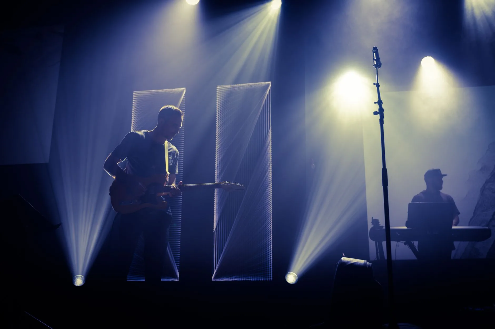 Konser sahnesinde gitar çalan müzisyen