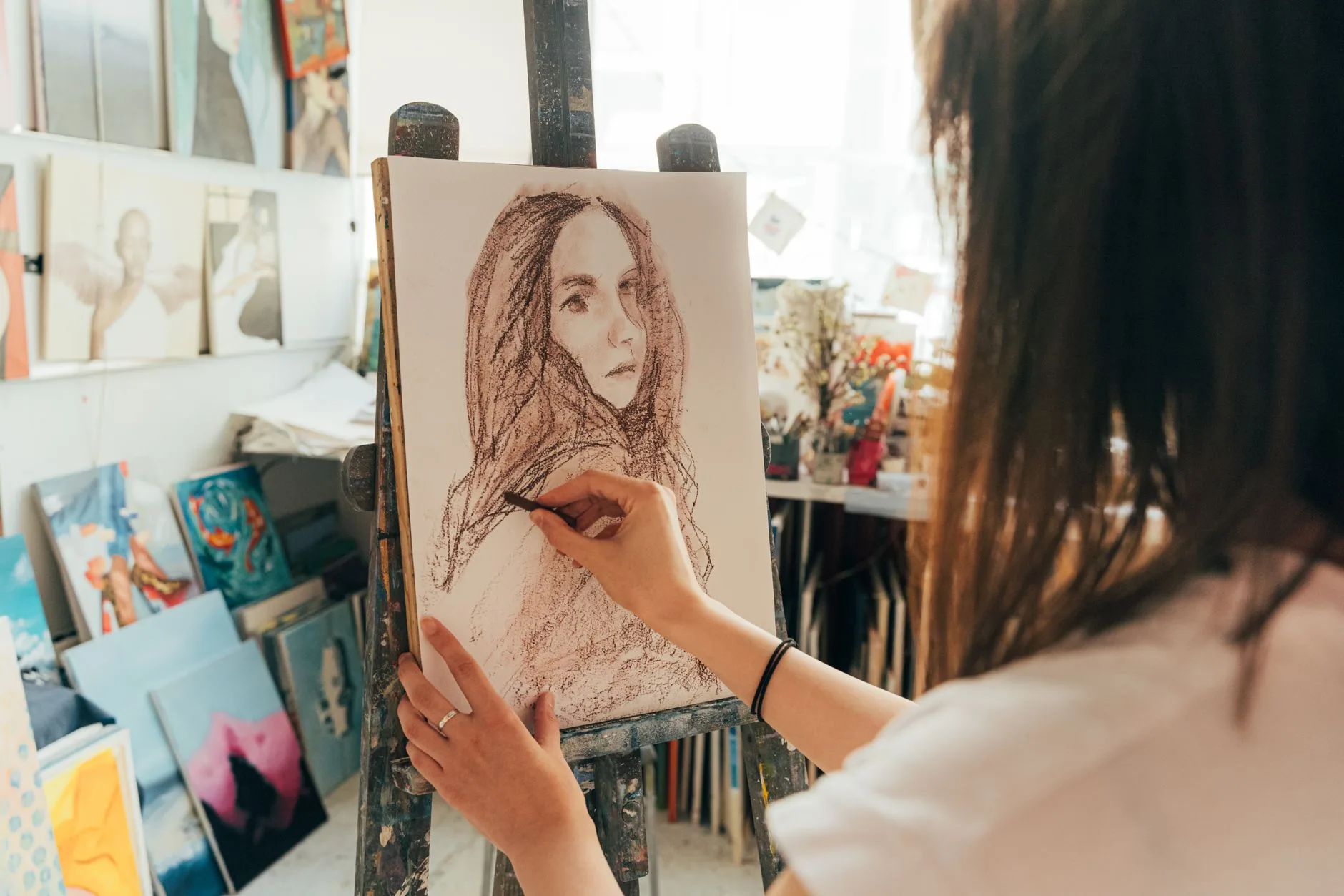 Sanat stüdyosunda portre çalışması yapan kadın