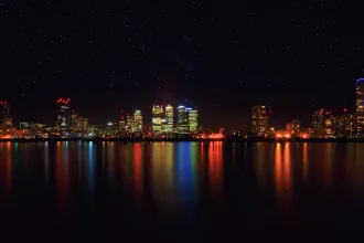 Gece ışıkları altında şehir silüeti ve süper kahraman filmi atmosferi