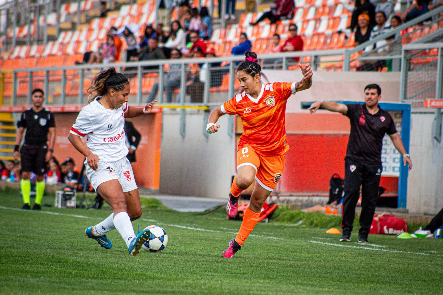 Stadyumda futbol oynayan kadın sporcular
