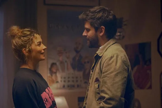 Şehir ışıkları altında yan yana duran romantik çift