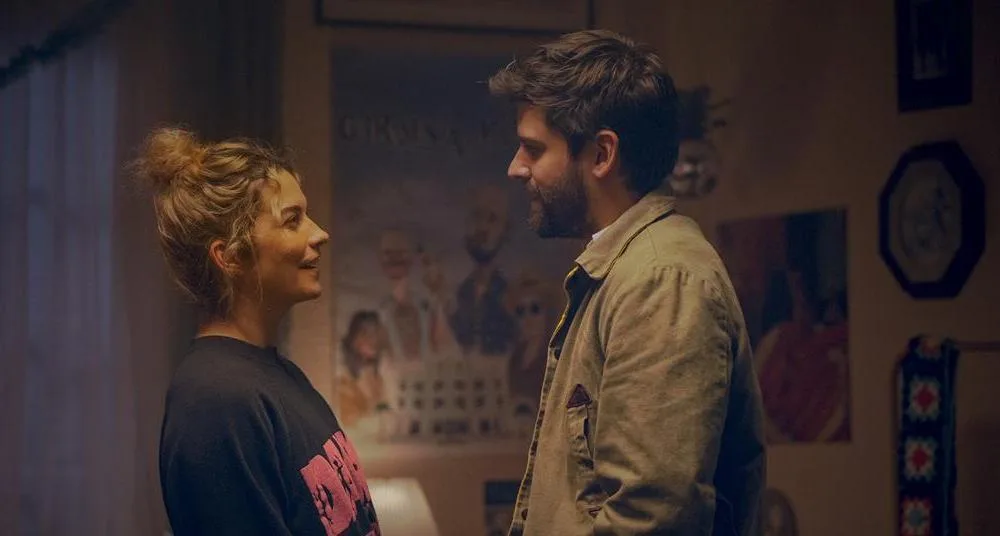 Şehir ışıkları altında yan yana duran romantik çift