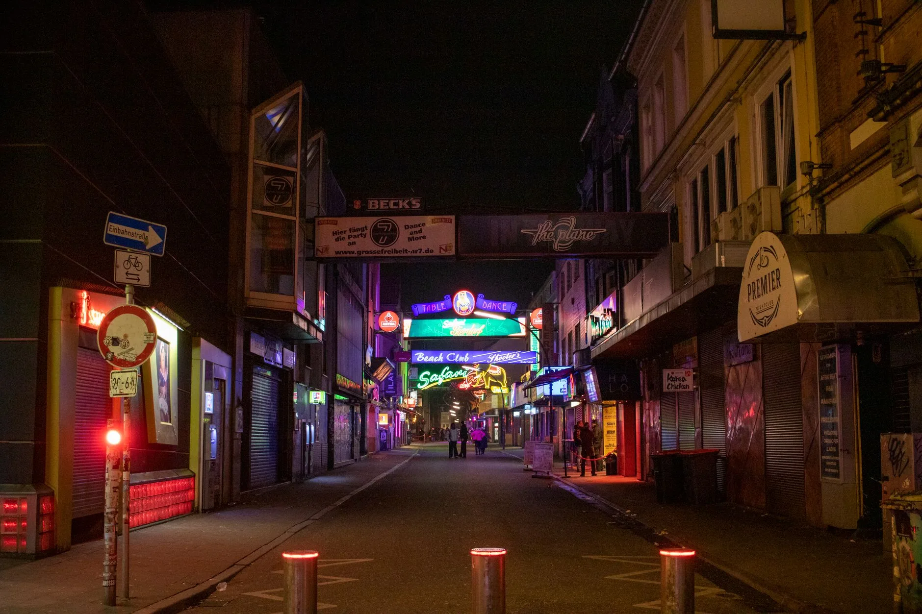 Neon ışıkları altındaki boş bir gece kulübü sokağı