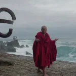 San Sebastian sahilinde yavaş yürüyen kırmızı cübbeli keşiş