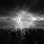 Kalabalık bir stadyumda sahne alan rock grubu ve konser izleyicileri