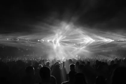 Kalabalık bir stadyumda sahne alan rock grubu ve konser izleyicileri