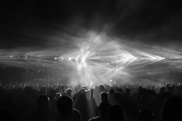 Kalabalık bir stadyumda sahne alan rock grubu ve konser izleyicileri