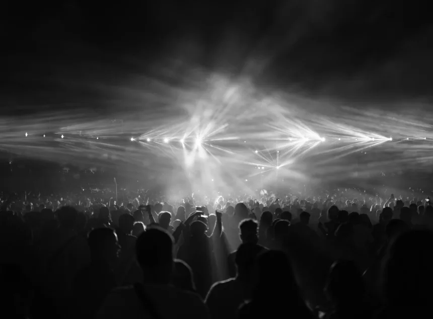 Kalabalık bir stadyumda sahne alan rock grubu ve konser izleyicileri