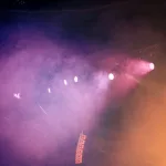 Dancehall konserinde renkli ışıklar altında sahne alan müzisyen