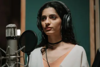Kayıt stüdyosunda mikrofon başında müzik hazırlayan sanatçı