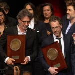 Film festivalinde ödül töreni sırasında sahnedeki sinemacılar