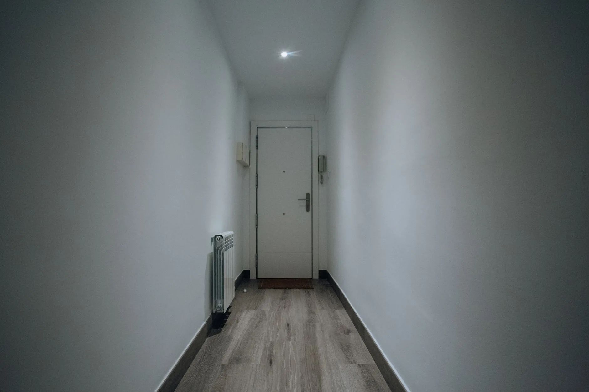 Loş ışıklı bir koridorda kapalı ön kapı