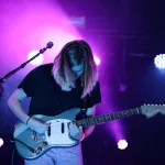 Sahnede gitar çalan bir müzisyen