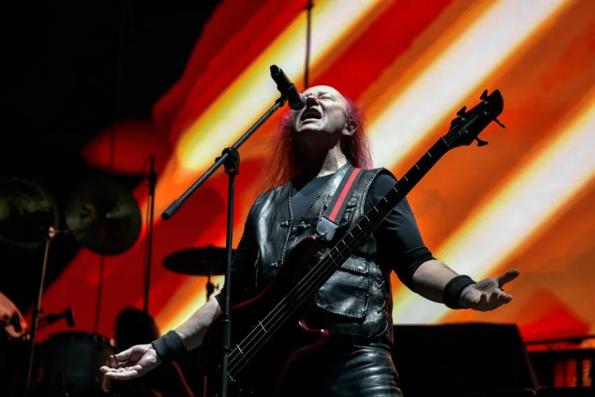 Karanlık sahnede performans sergileyen heavy metal müzisyenleri
